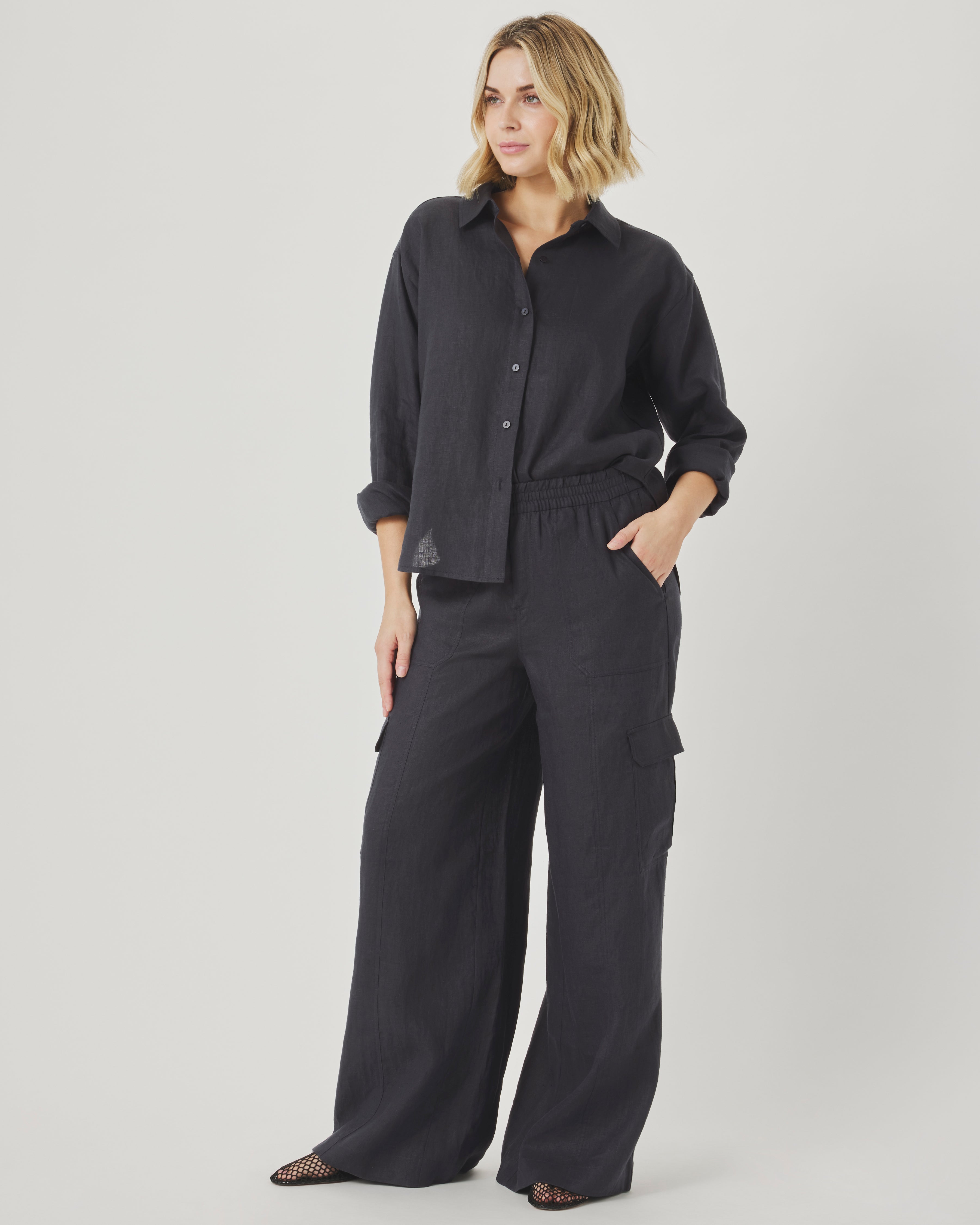 Woman wearing black cargo pants with a linen shirt in summer